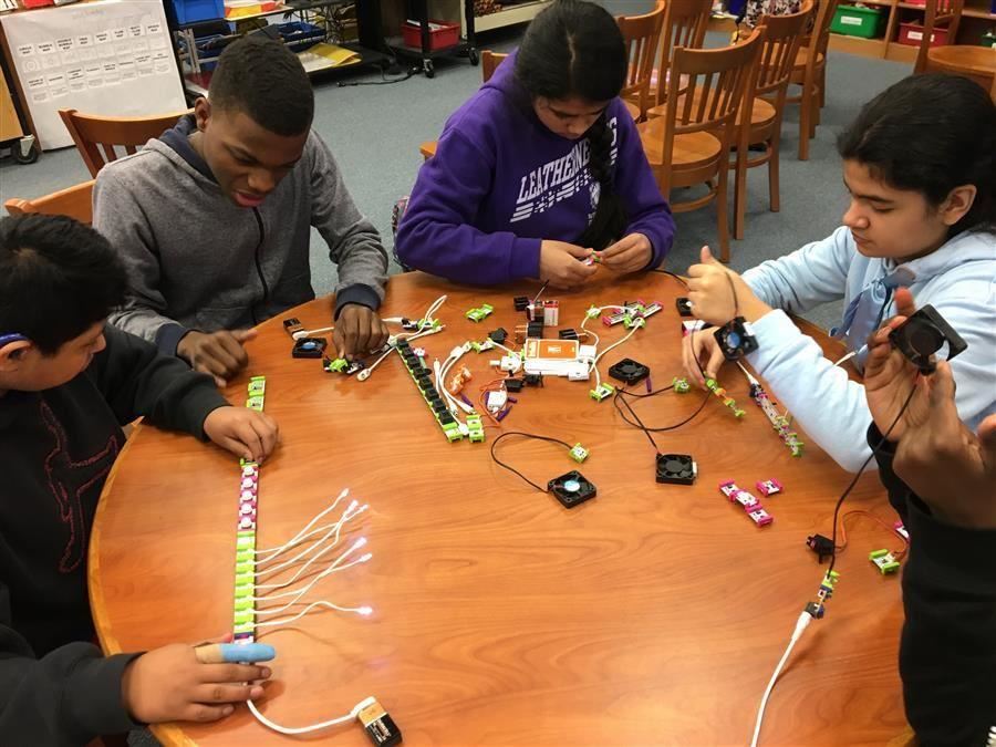 Group of students at a table working on electronics called Little Bits 