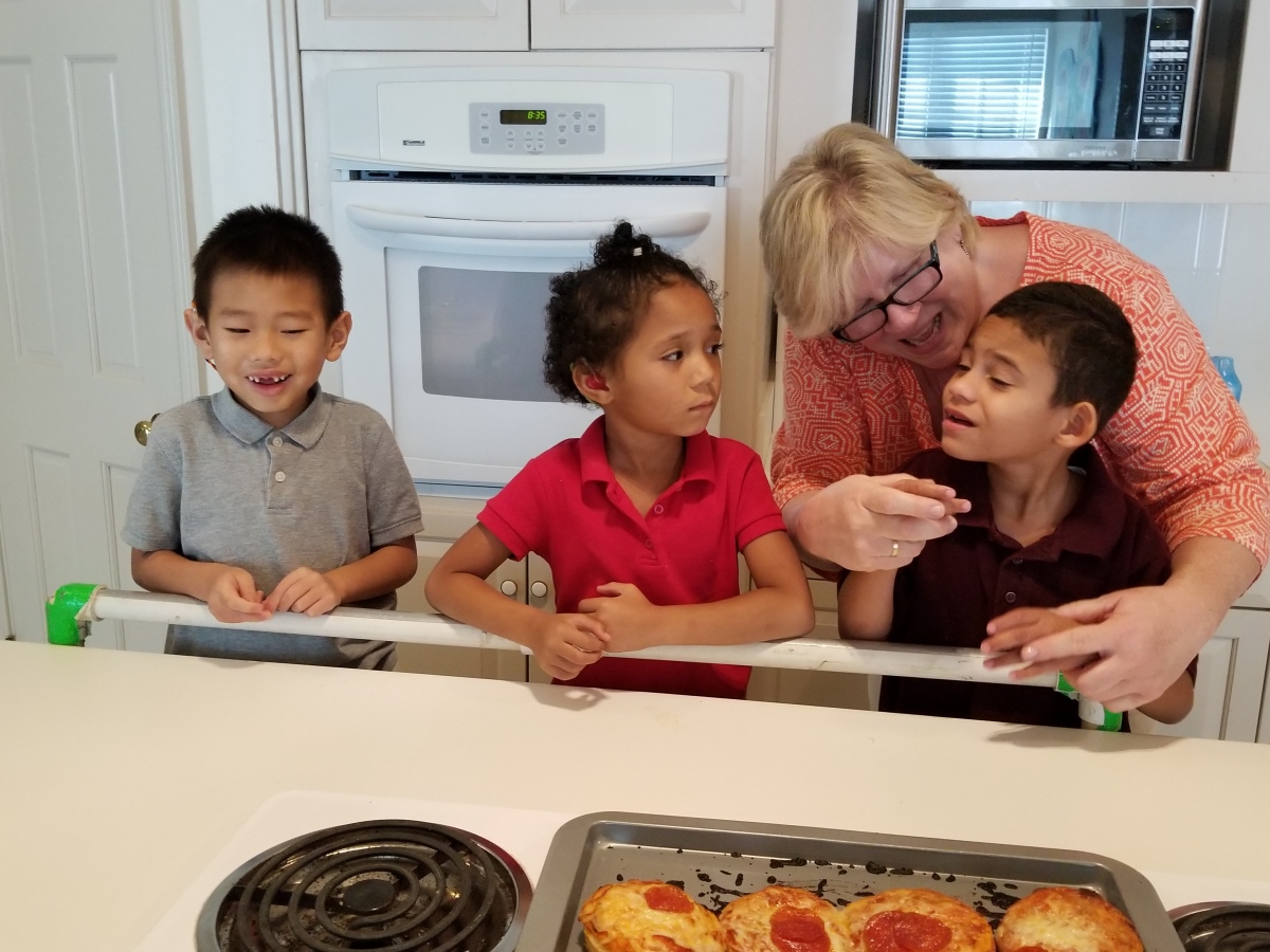 Two male students, one female student, and a Speech Therapist participate in a cooking activity. 