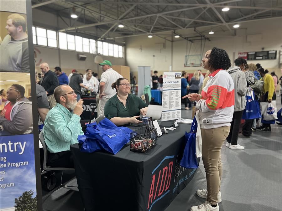  A student speaking with representatives at career day.