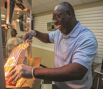 A student in EHG's Business Enterprise Program fills a bag of popcorn for a customer 