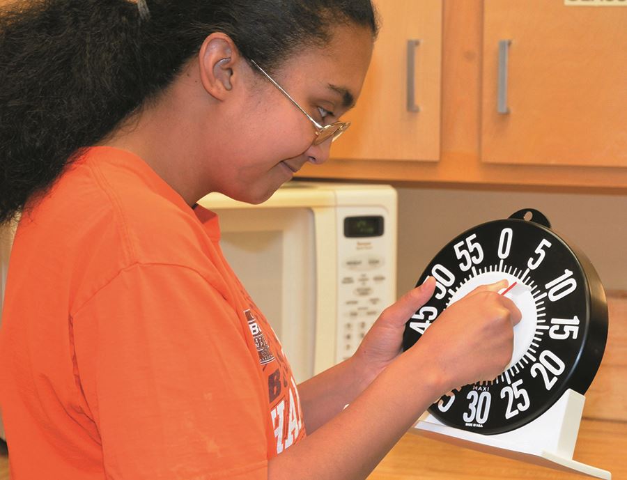 A DeafBlind client at EHG learns to use a timer with oversized numbers A DeafBlind client at EHG learns to use a timer with oversized numbers