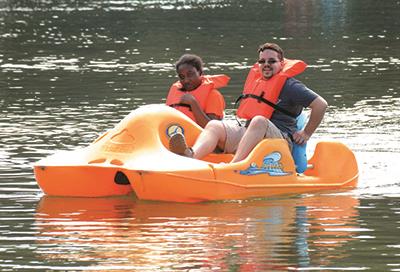 Two EHG clients enjoy a paddleboat ride during a day on the lake 