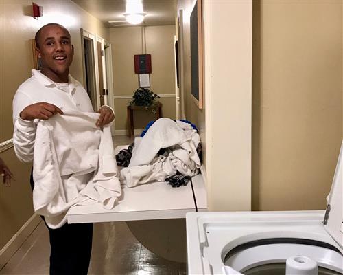 teen male student folding laundry 