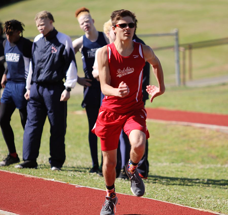 A member of the ASB boys' track team running during a meet