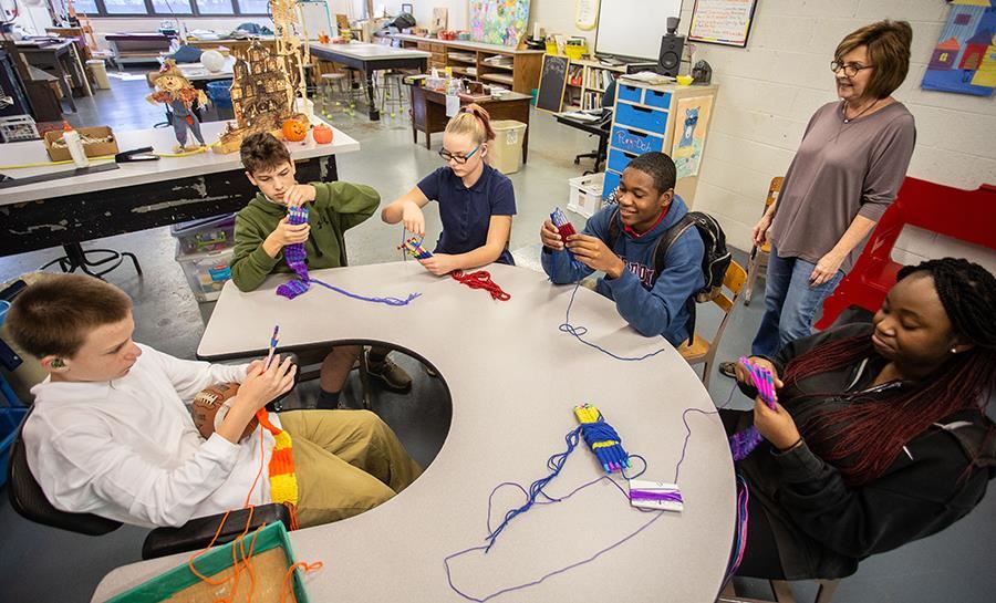 A teacher and her students work on a class project at ASD 