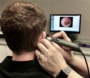 audiologist conducting an examine on a student  