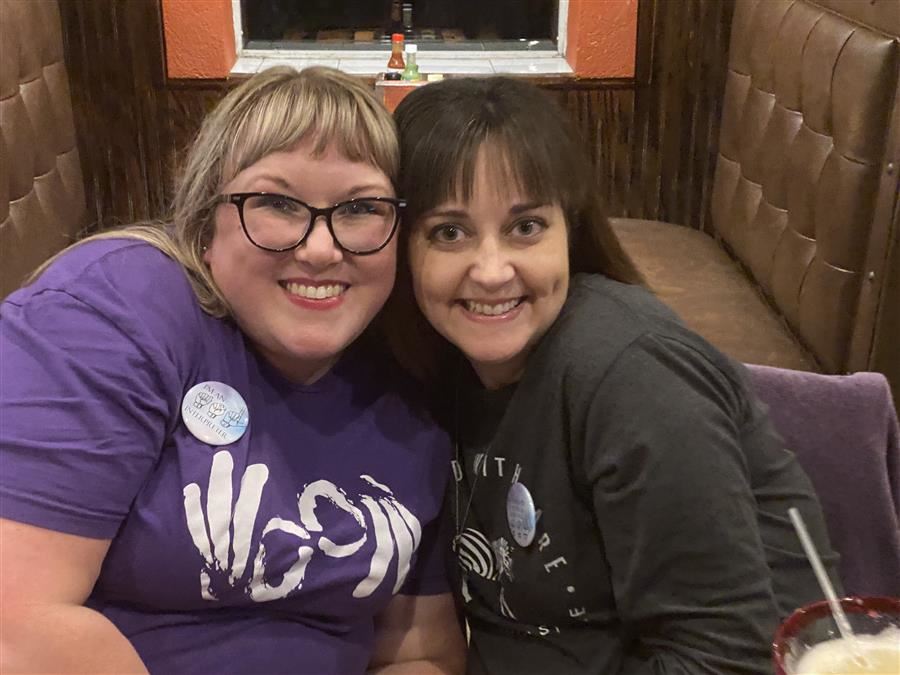 Two women smile to camera.