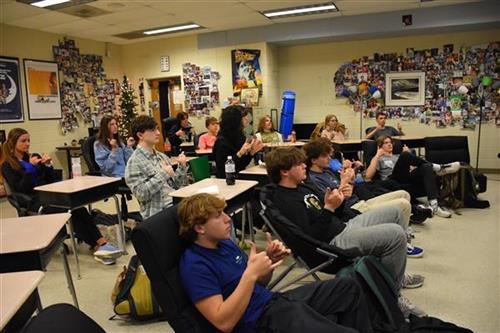 A classroom full of students practicing ASL.