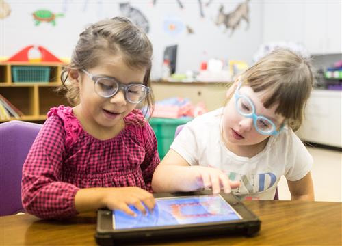 Two girls playing with iPad 