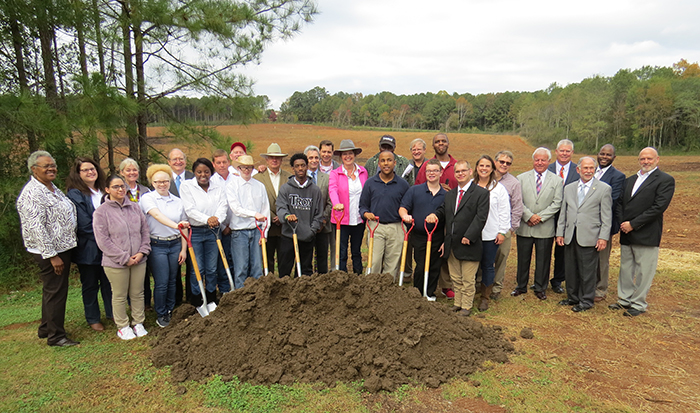 The JTA Ground Breaking. There are students and staff holding shovels in the ground. 