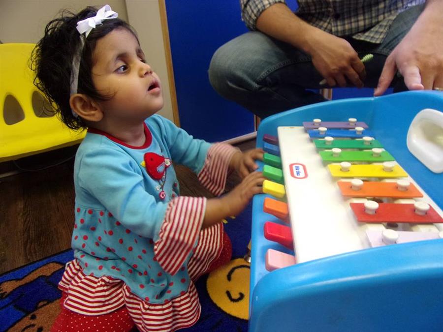 A toddler with a play xylophone.