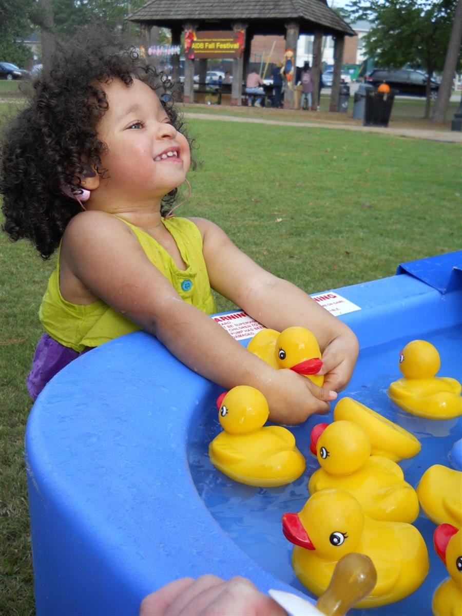 A toddler playing with rubber ducks.
